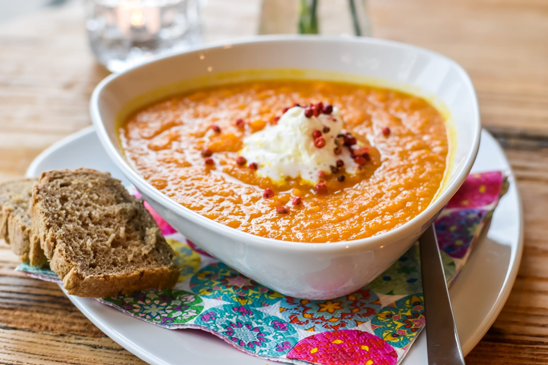Ein Teller Suppe mit einigen Brotscheiben daneben.