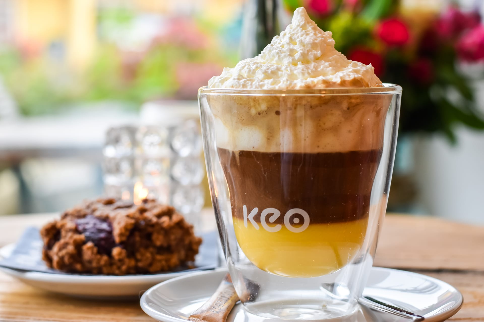 Eine Tasse Kaffee mit Schaum und ein Teller mit Kuchen.