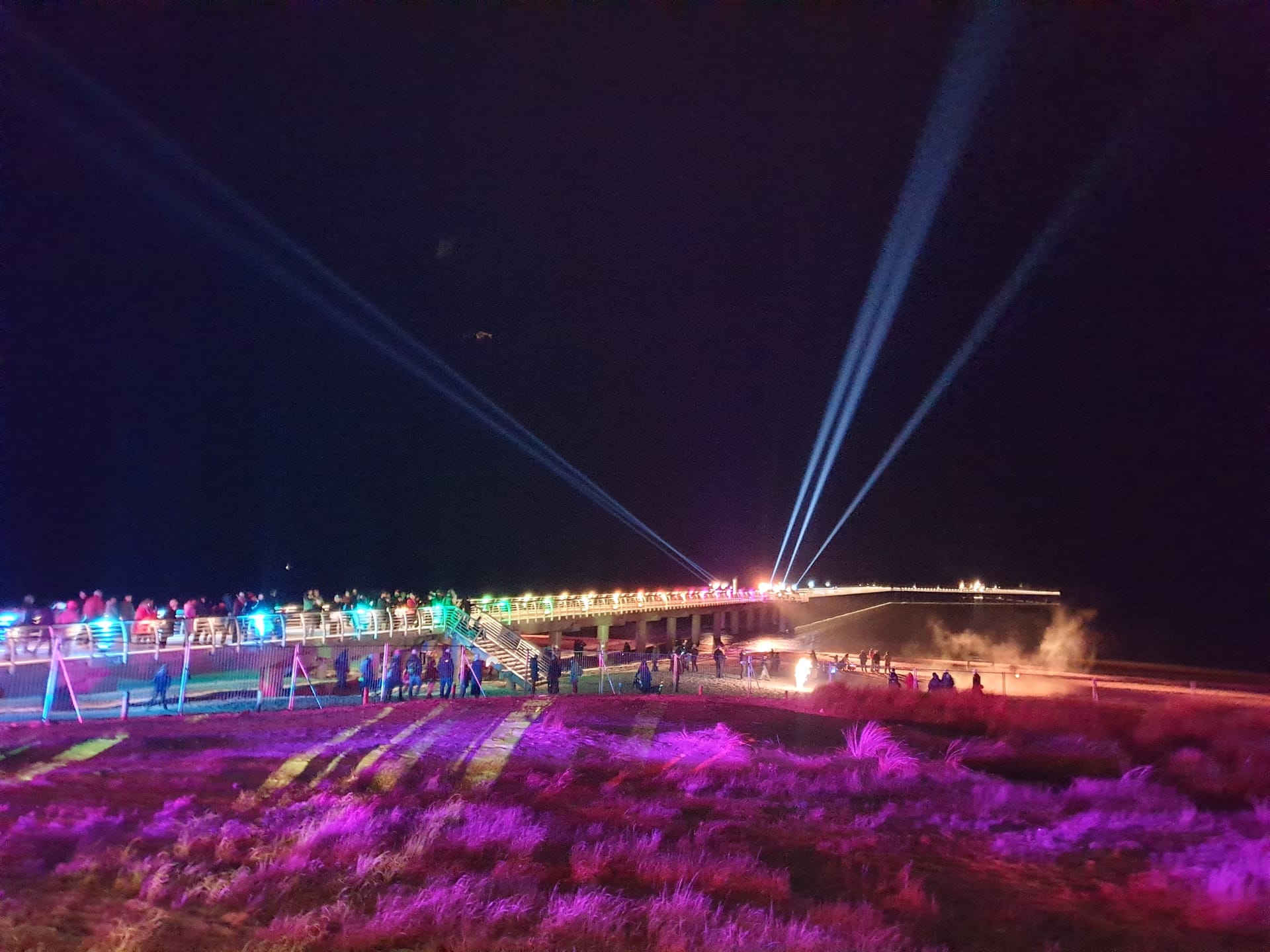 Trubel auf der Seebrücke am Abend, viele bunte Lichter.