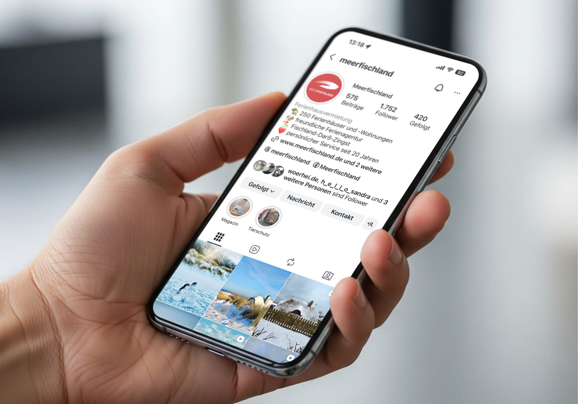 Hand hält Smartphone mit Instagram-Profil der Ferienagentur Meerfischland