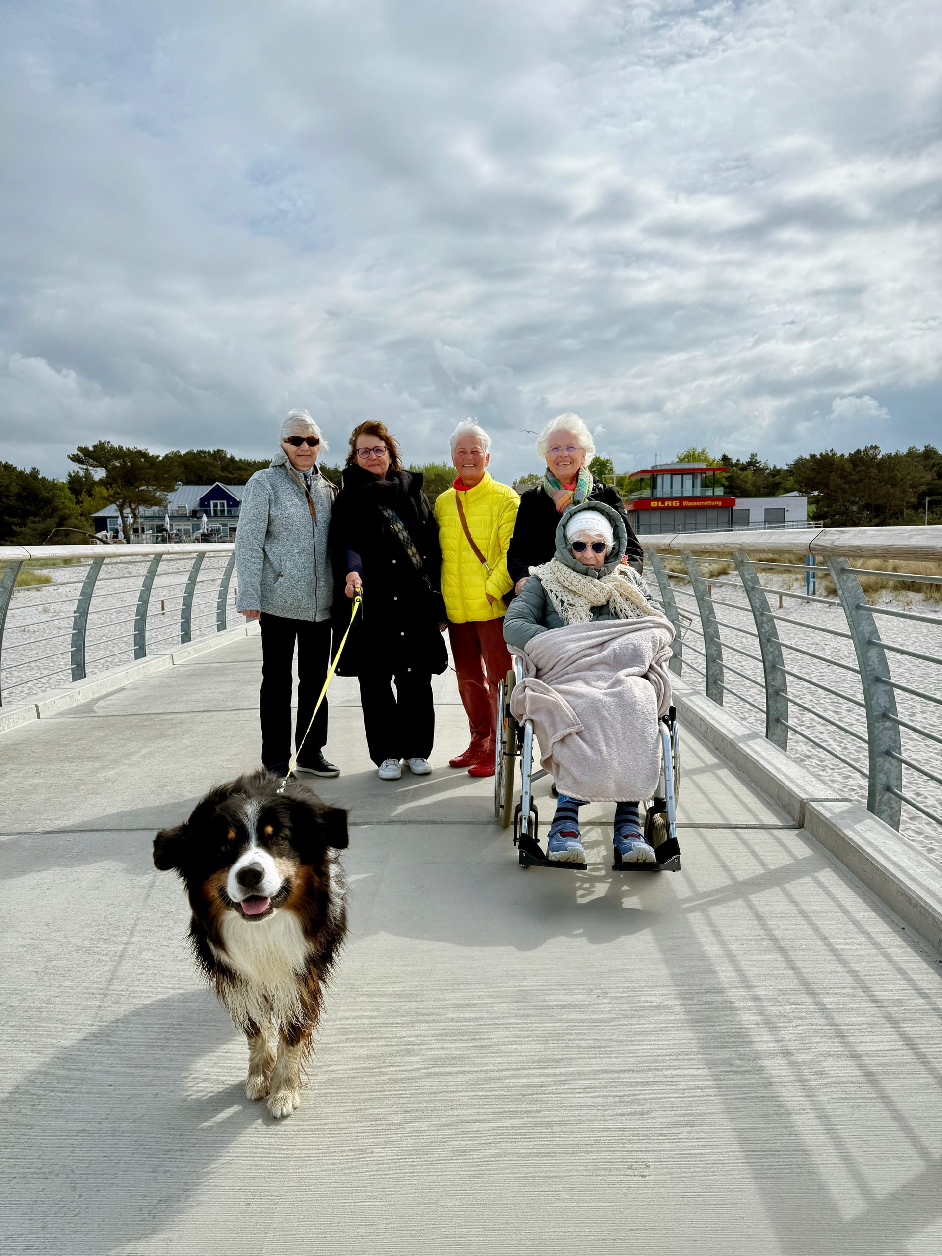 Gemeinsamer Spaziergang auf der Seebrücke mit Hund und Rollstuhl