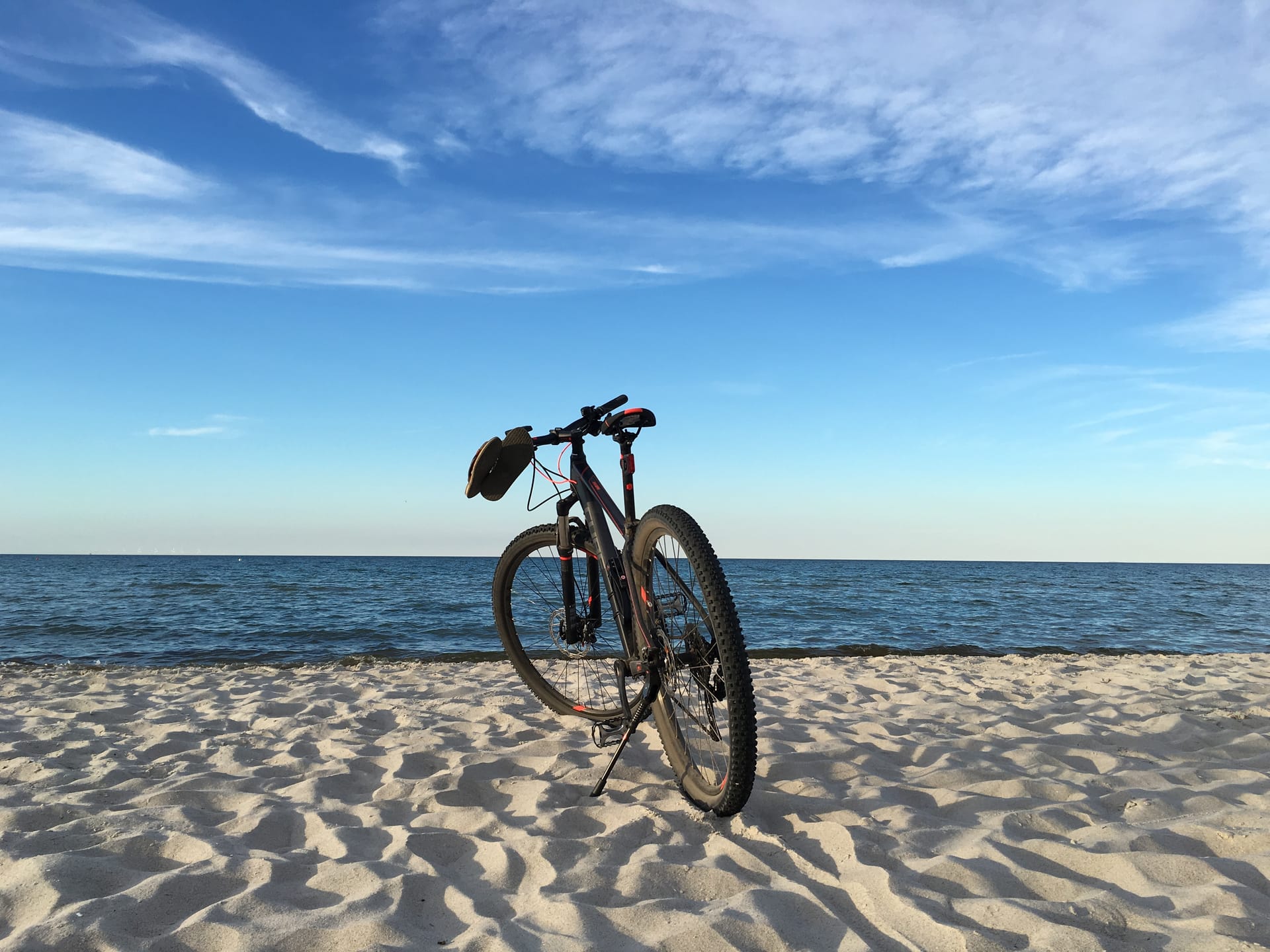Fahrrad im Sand am Ostseestrand mit Blick aufs Meer