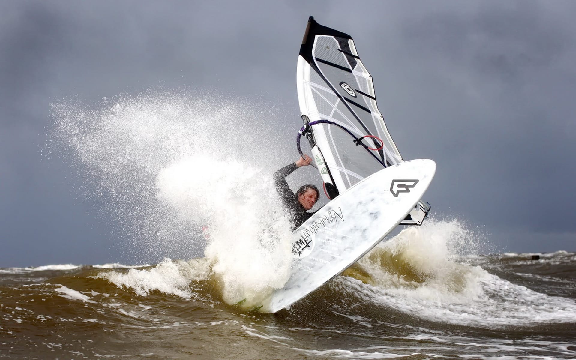 Windsurfer springt über Welle bei stürmischer See 