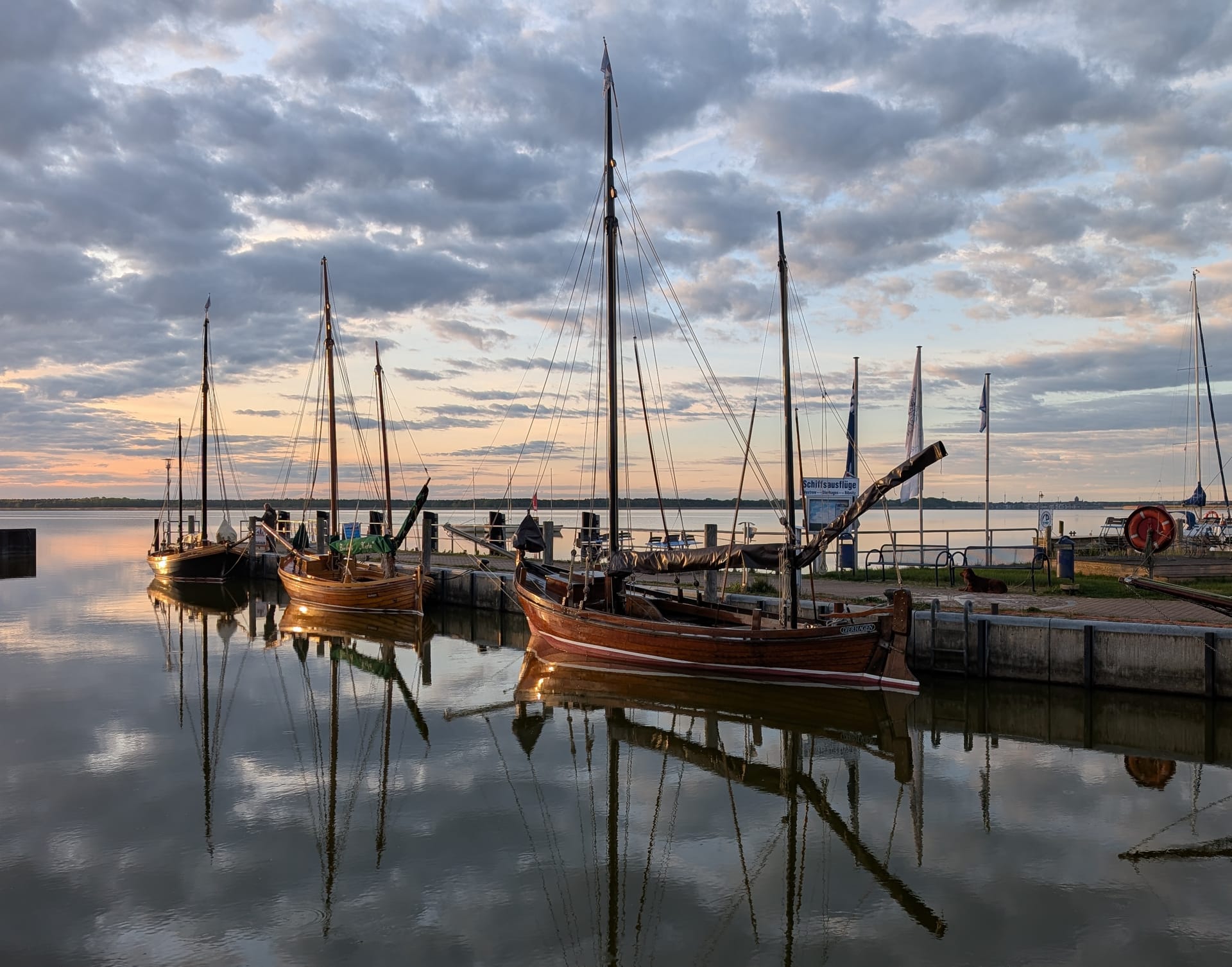 Historische Segelboote im Hafen bei Sonnenuntergang