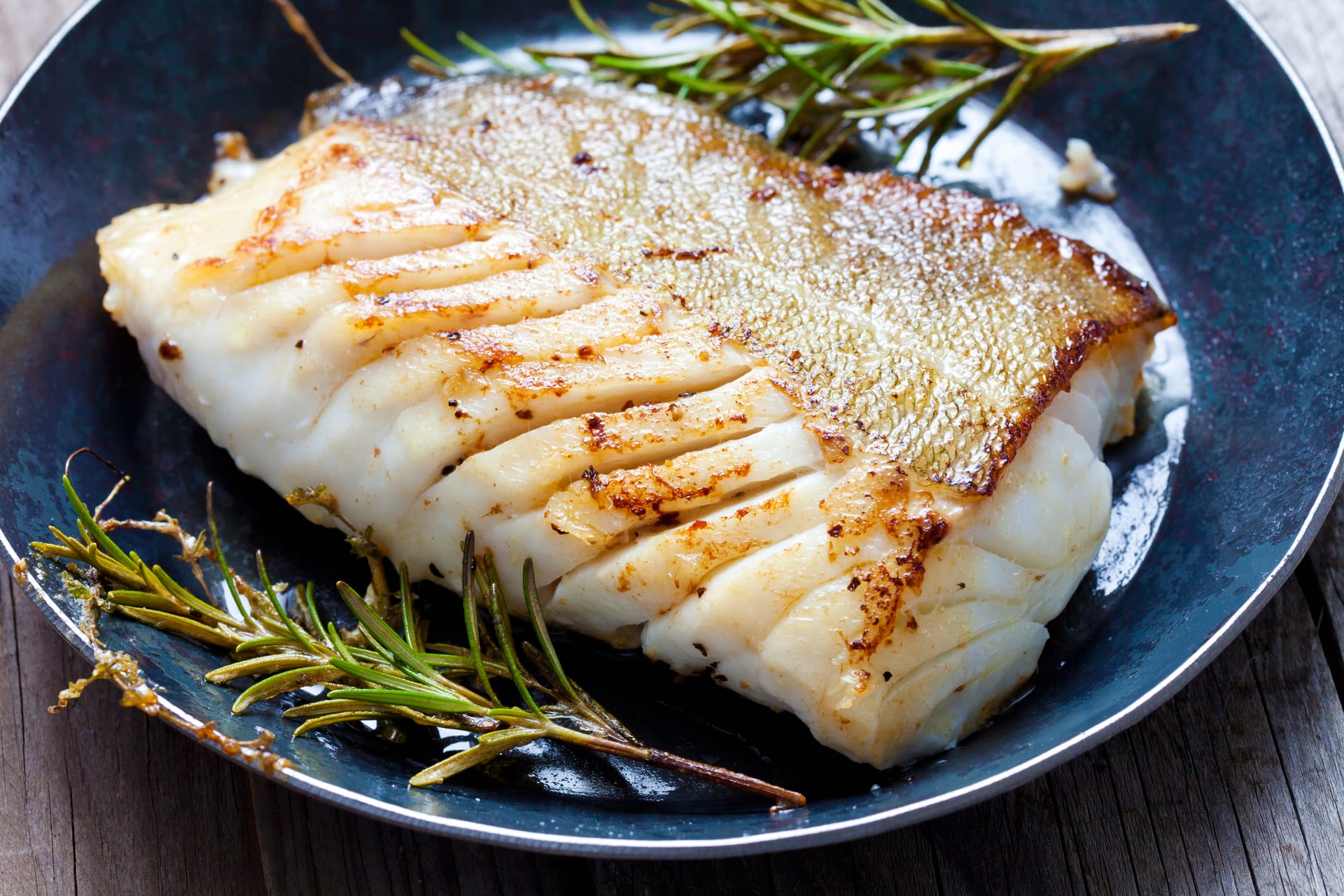 braun gebratener Weißfisch mit Rosmarin auf Teller