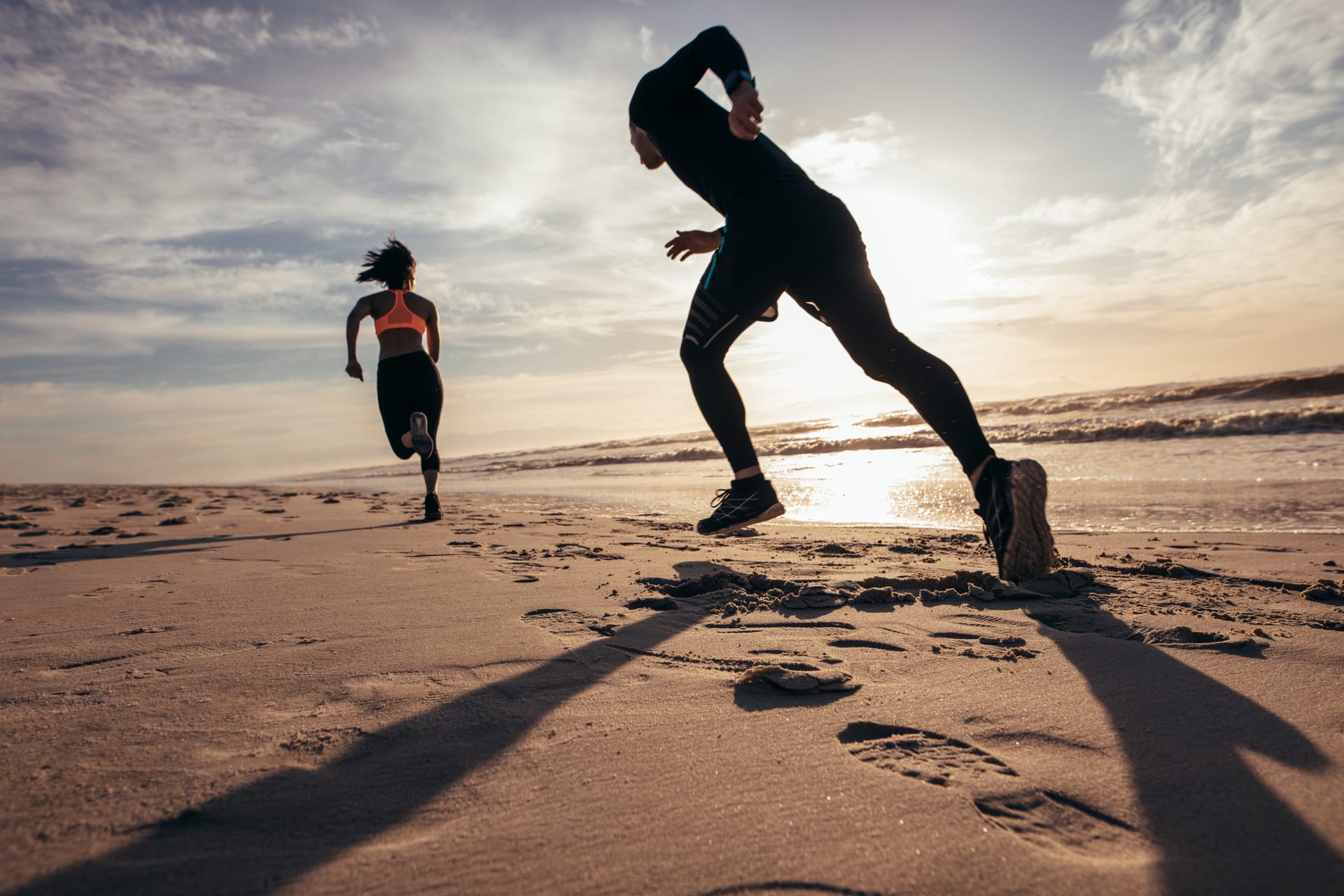Zwei Jogger laufen am Strand am Meer