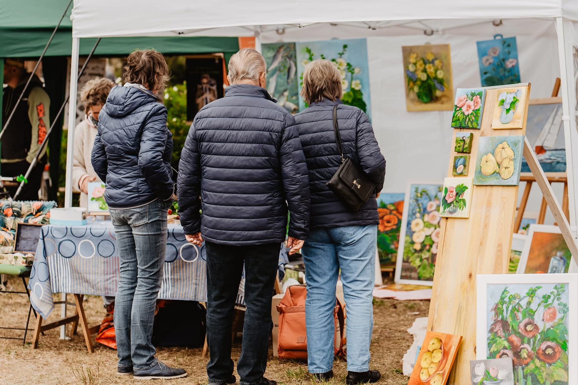 Menschen stehen an einem Kunststand auf Markt