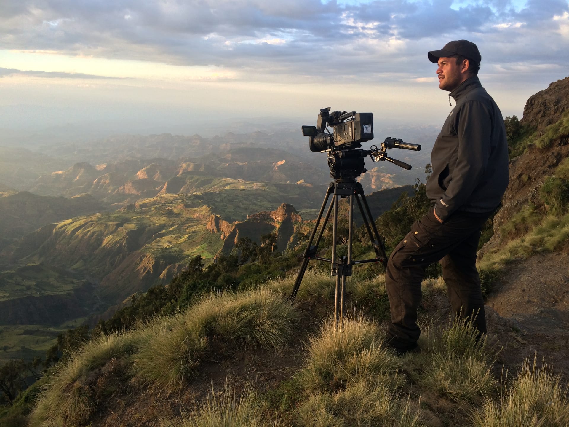 Naturfilmer steht am Berg mit seiner Kamera 