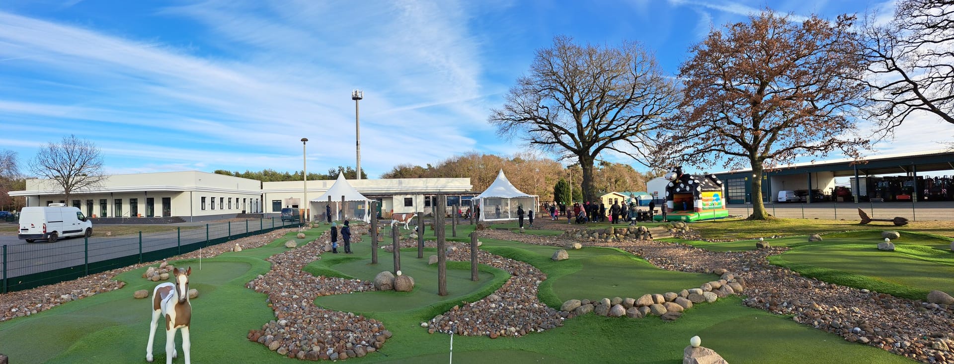 Minigolfanlage mit Spielbahnen, Figuren und Besuchern im Freien