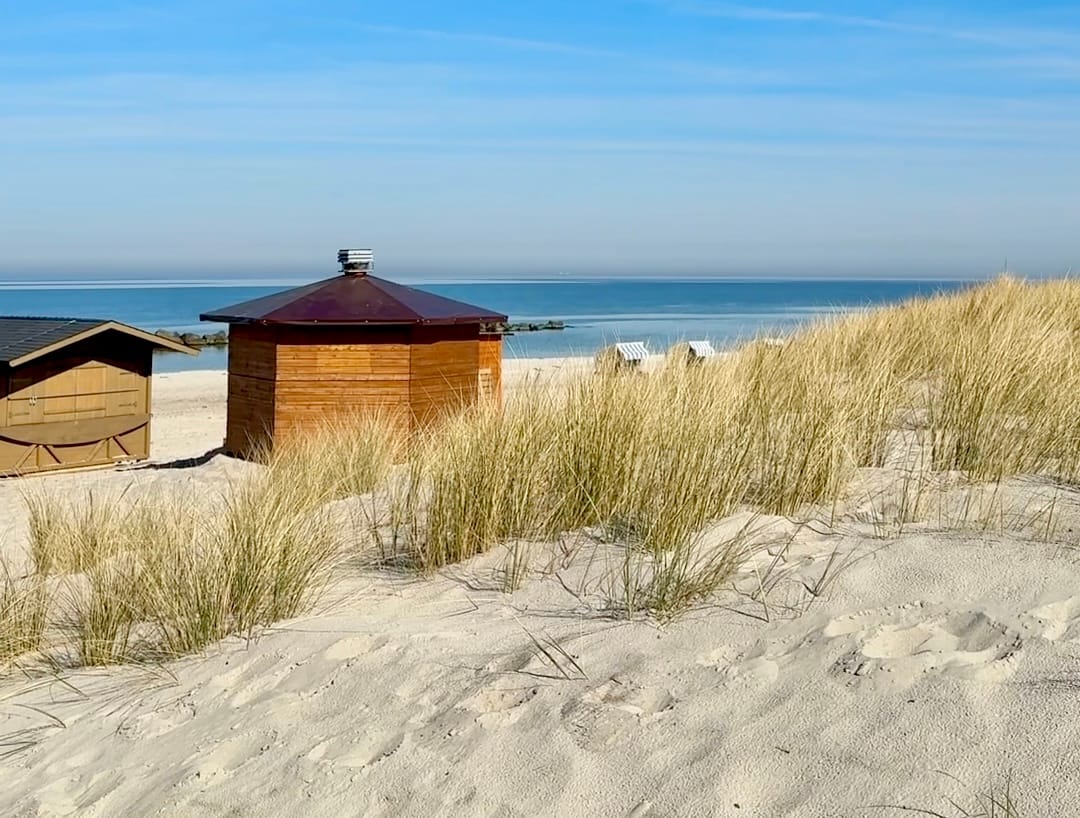 Dünenlandschaft mit Strandhäuschen und Blick auf die Ostsee