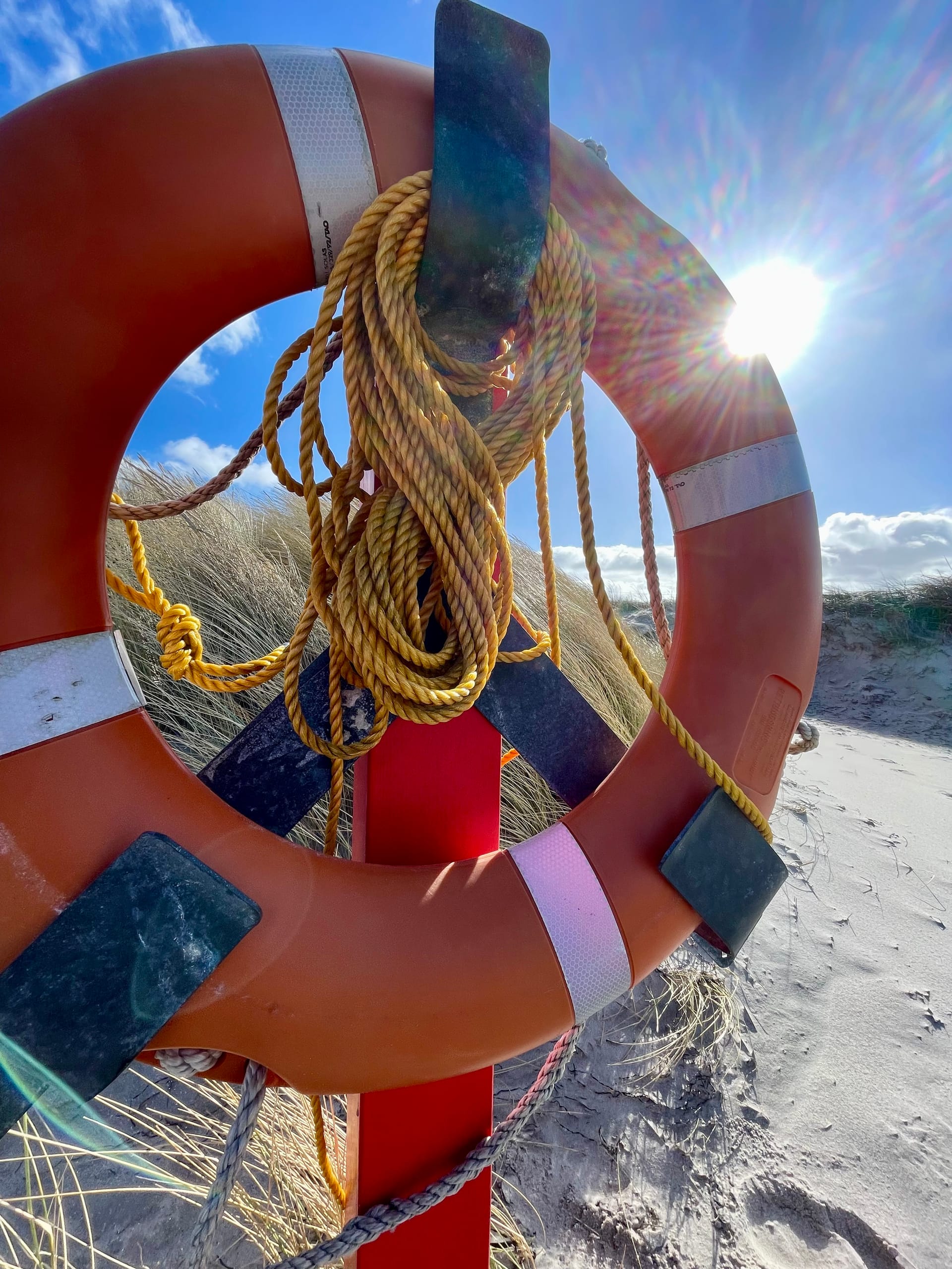 orangener Rettungsring am Strand