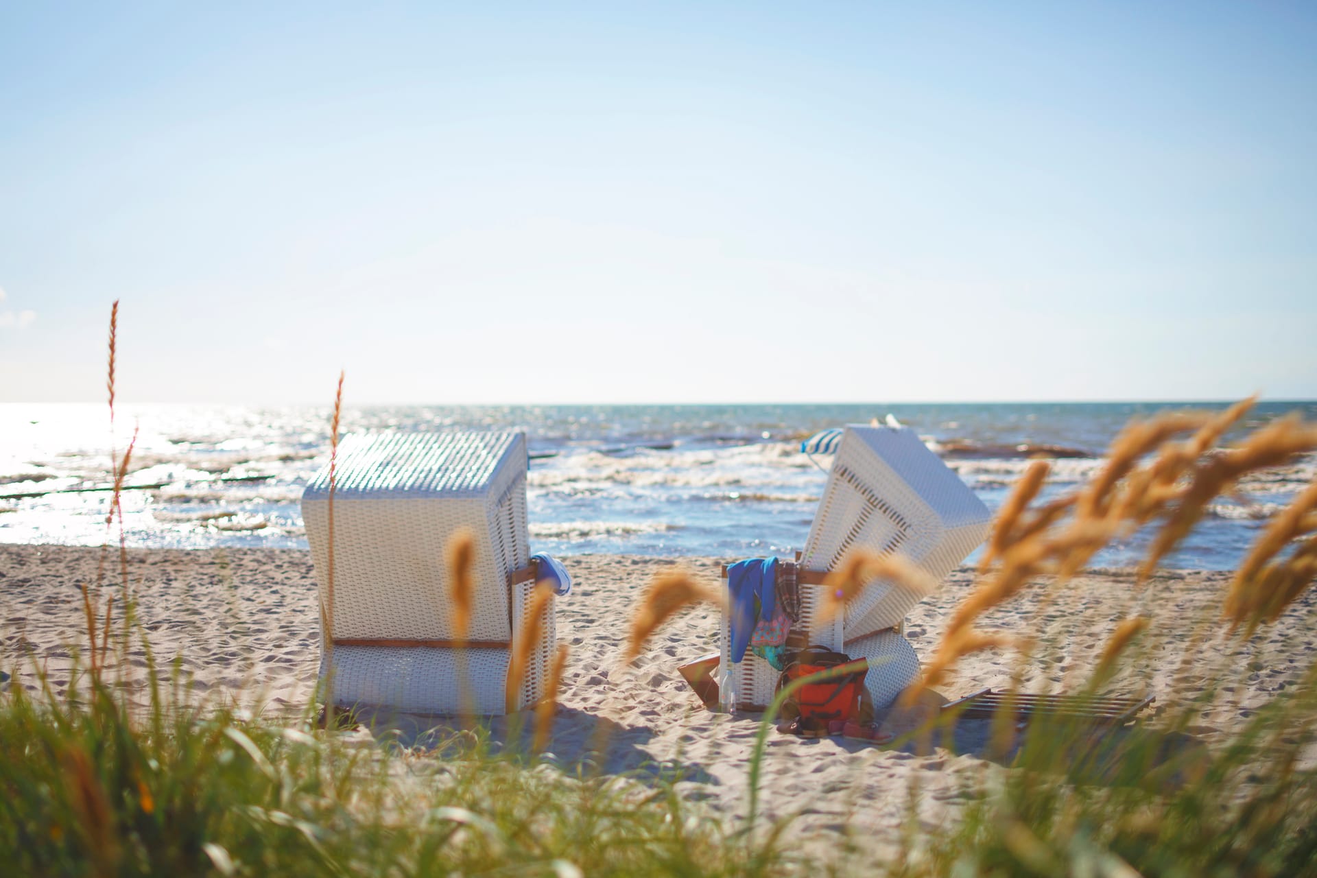 Strandkörbe am Strand bei strahlendem Himmel