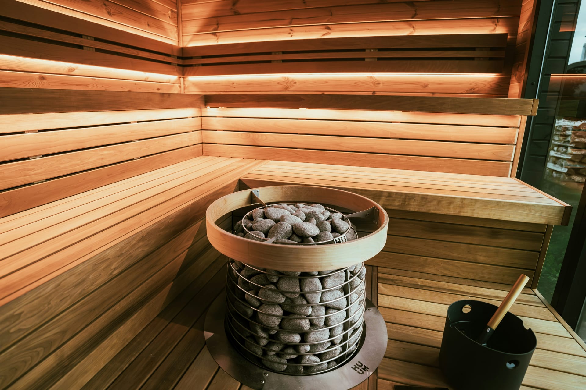 Modern gestaltete Sauna mit indirekter LED-Beleuchtung und Saunaofen.