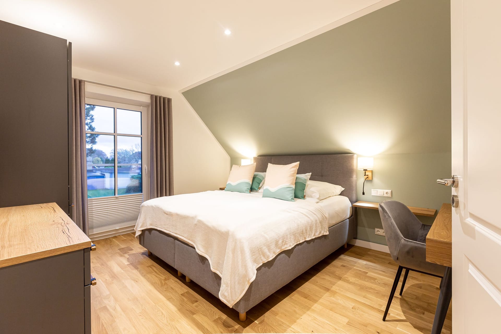 Schlafzimmer mit Doppelbett und Schreibtisch