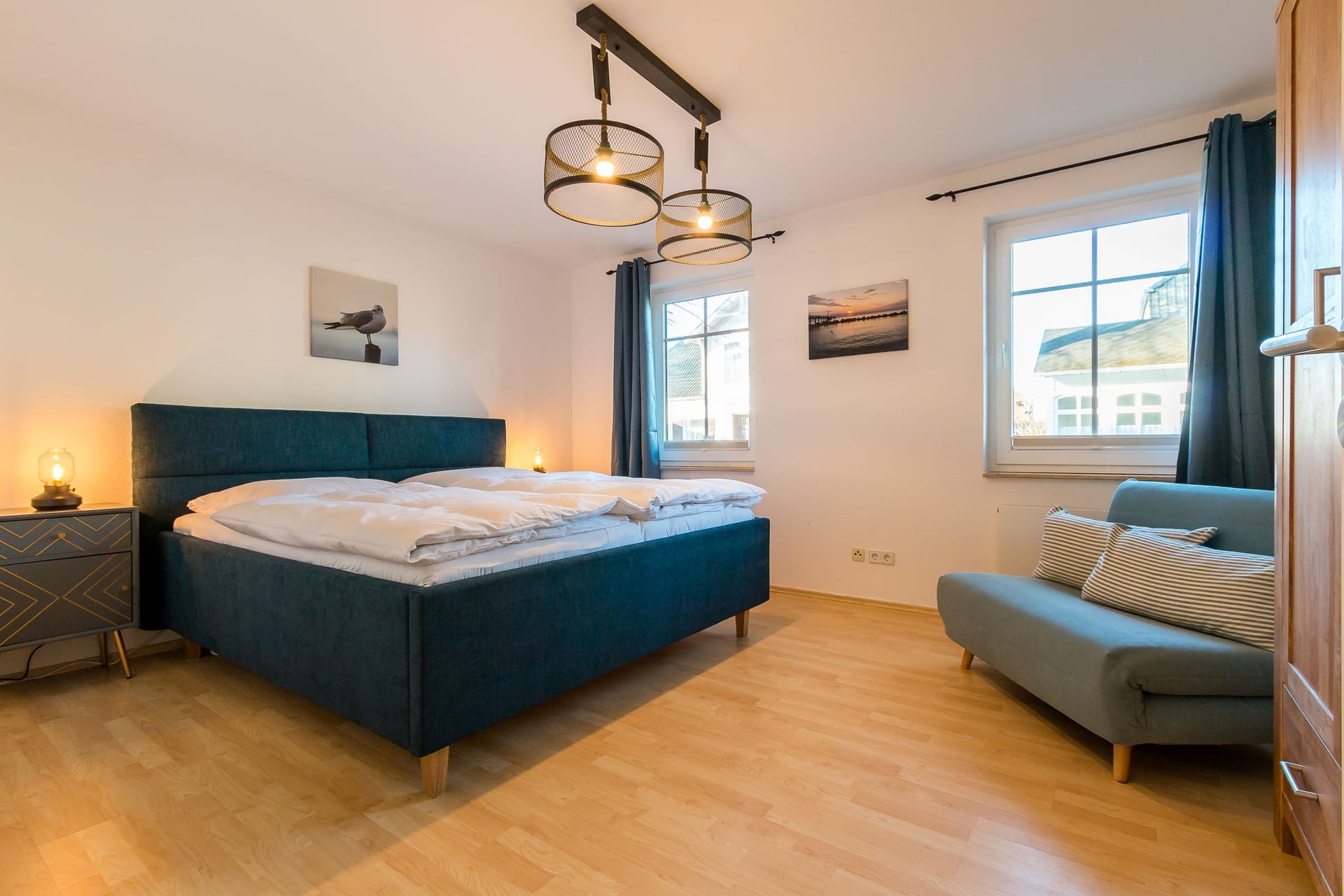 Schlafzimmer mit hellem Doppelbett und Fenster.