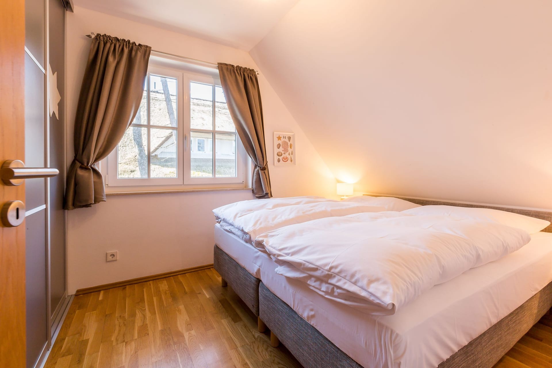 Schlafzimmer mit Doppelbett und Fenster.