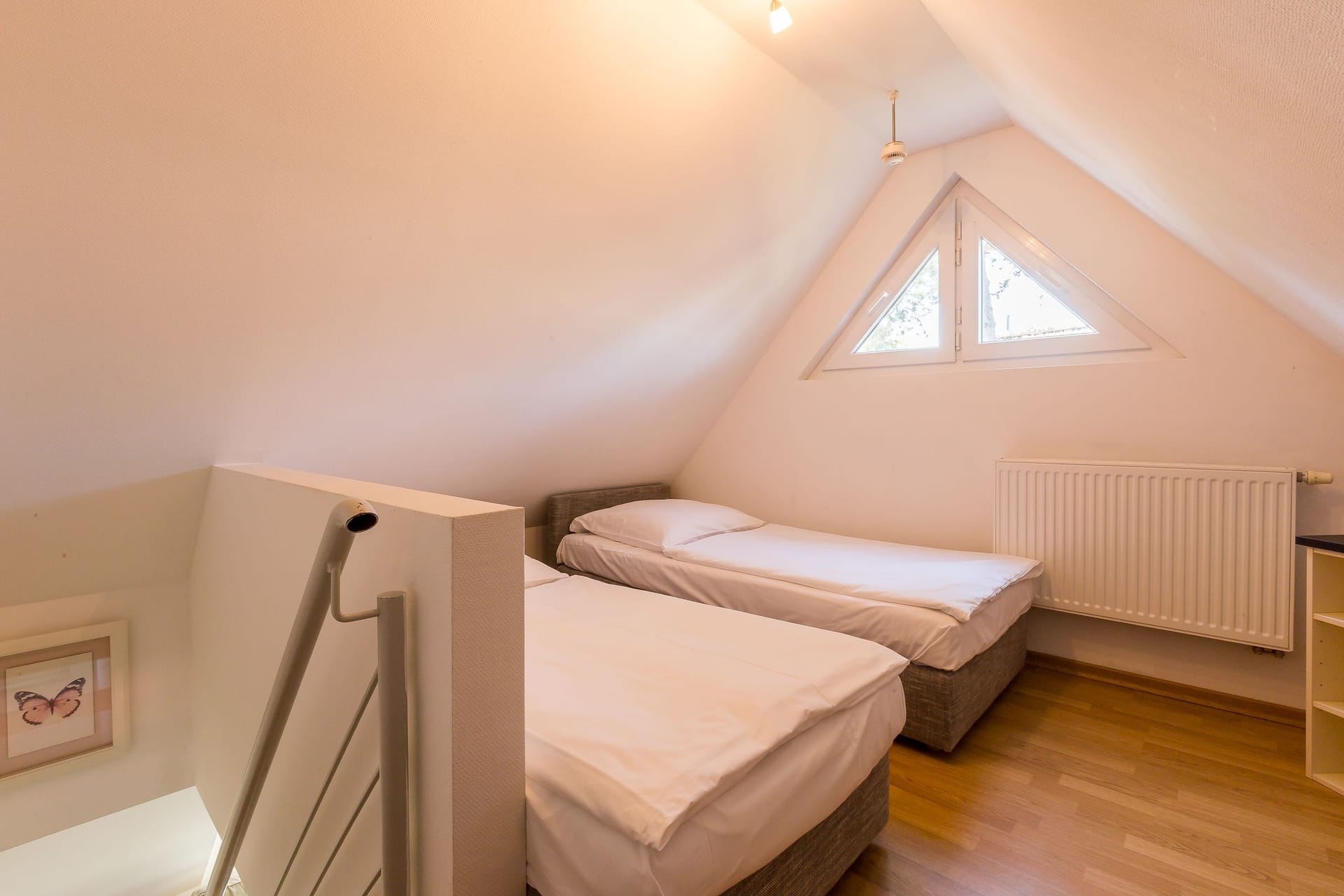 Schlafzimmer mit zwei Einzelbetten und Fenster.