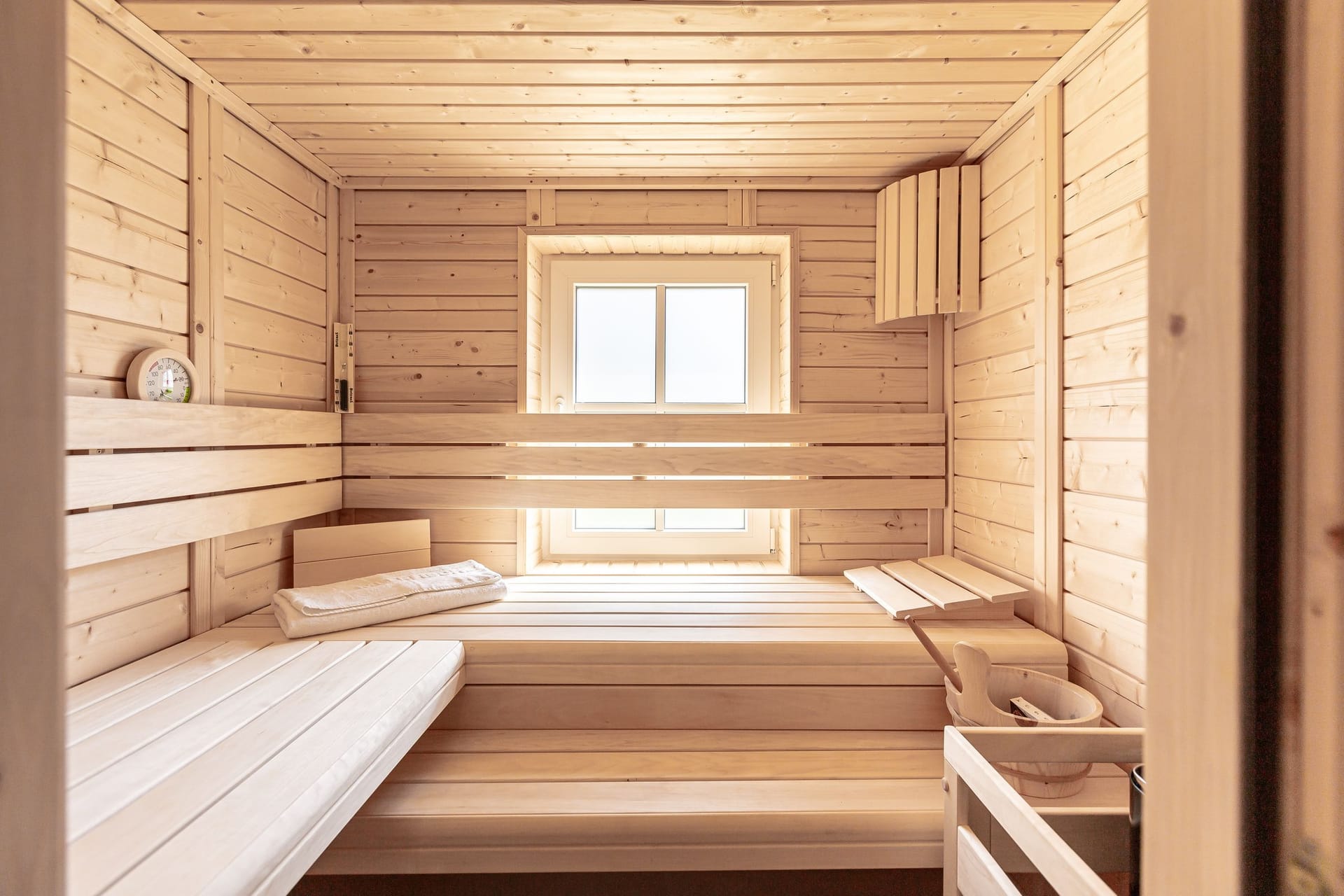 Moderne Holzsauna mit Fenster und Sitzbänken