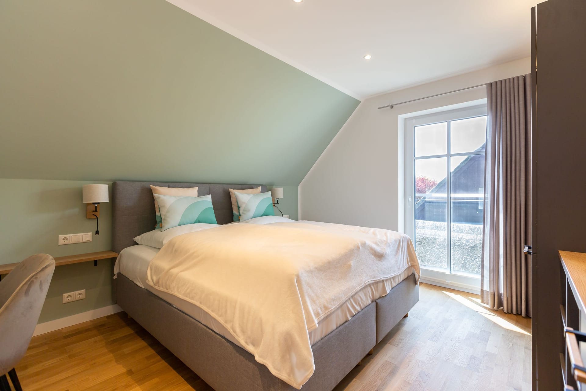 Helles Schlafzimmer mit Doppelbett und Gartenblick