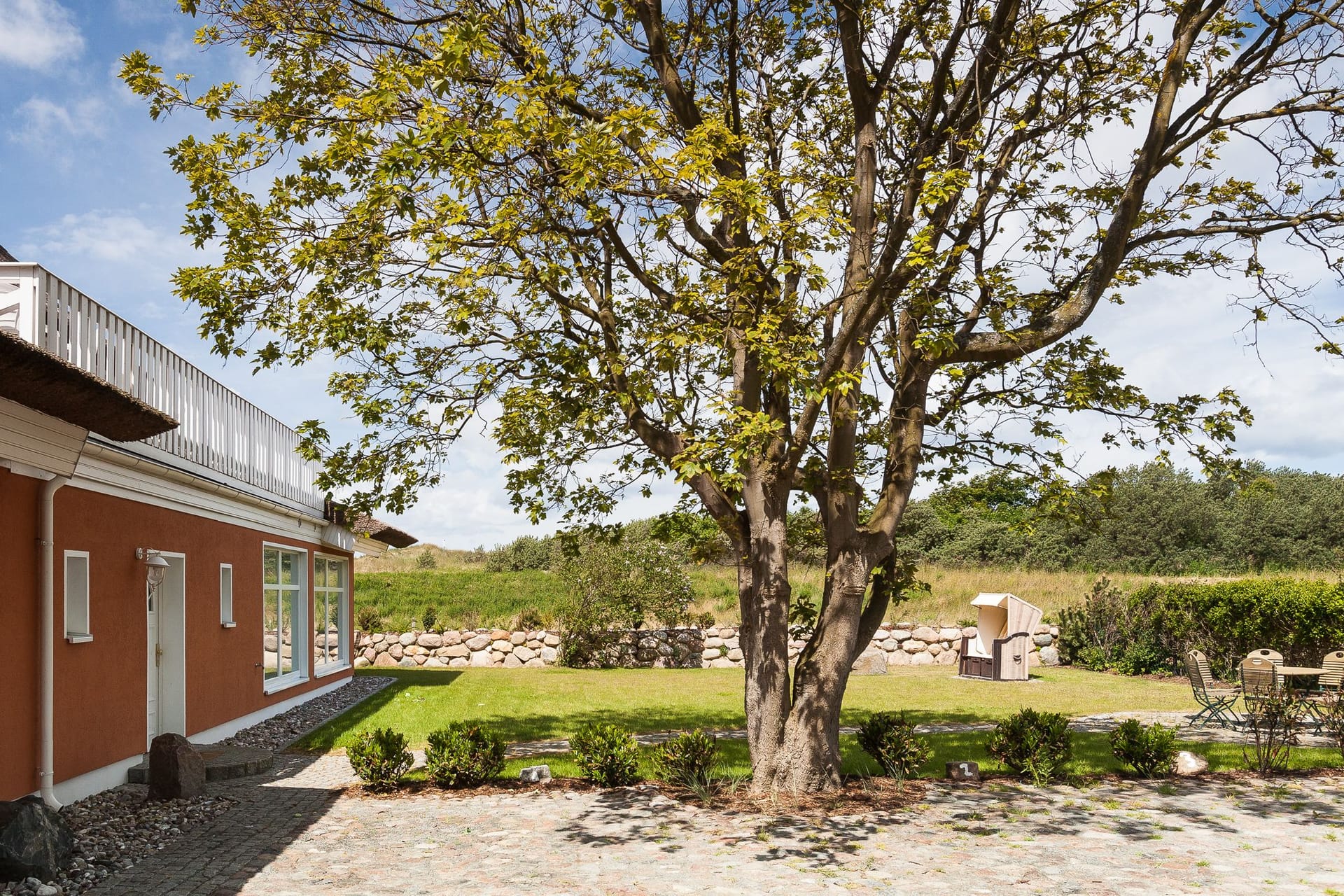 Außenansicht des Ferienhauses mit Garten und Baum