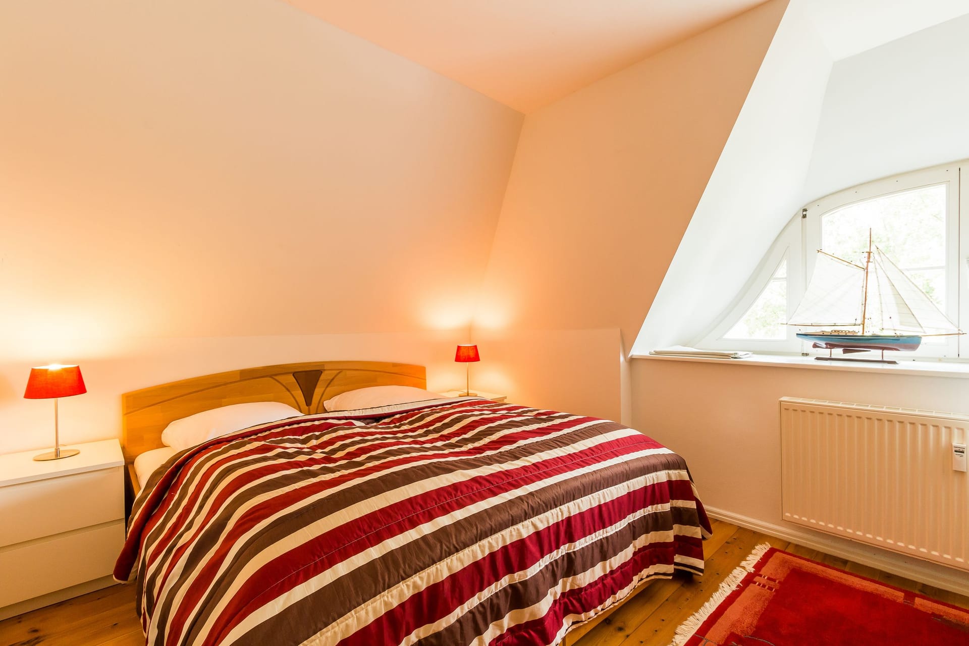 Schlafzimmer mit Doppelbett und dekorativen Lampen.