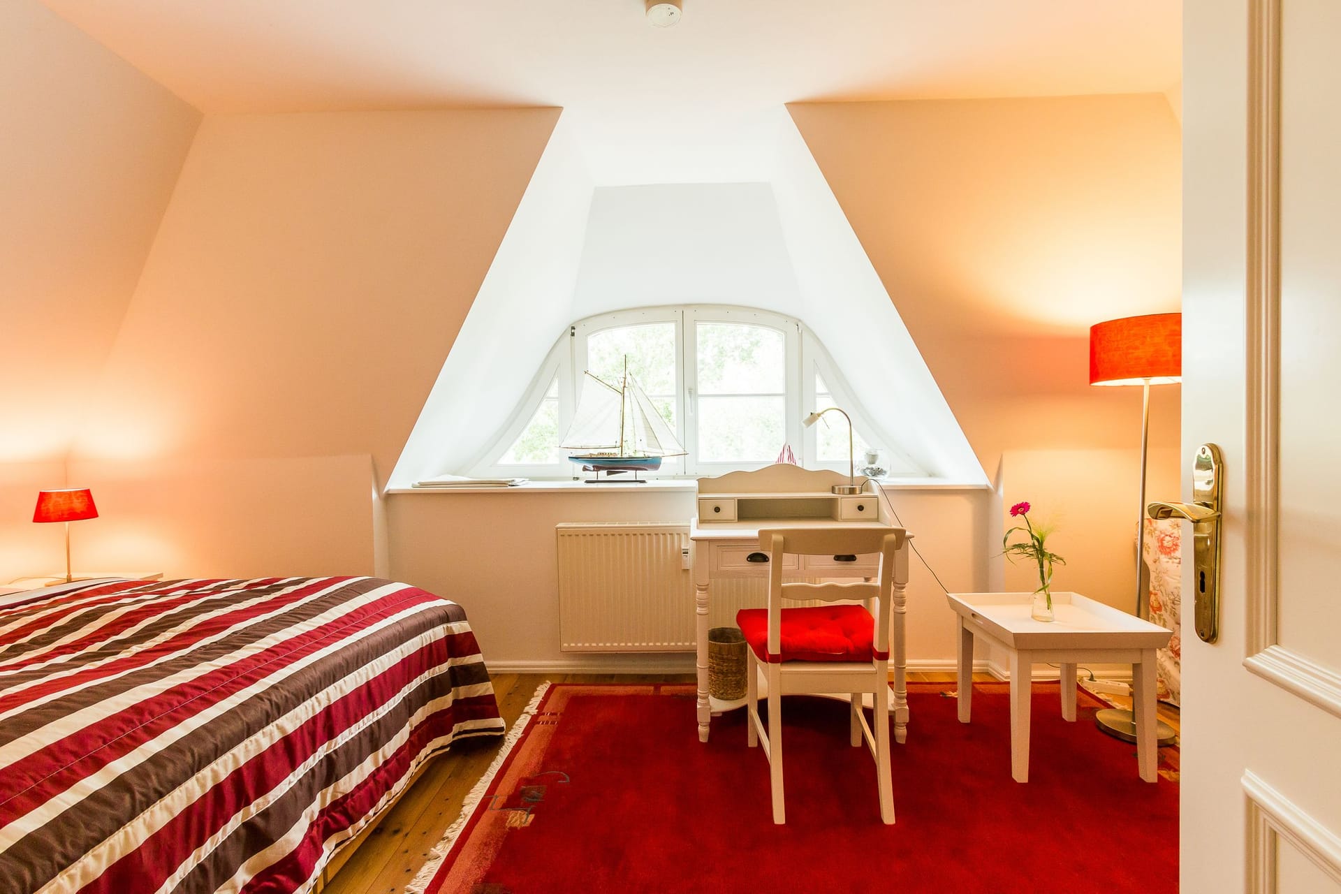 Gemütliches Schlafzimmer mit Schreibtisch und Fenster