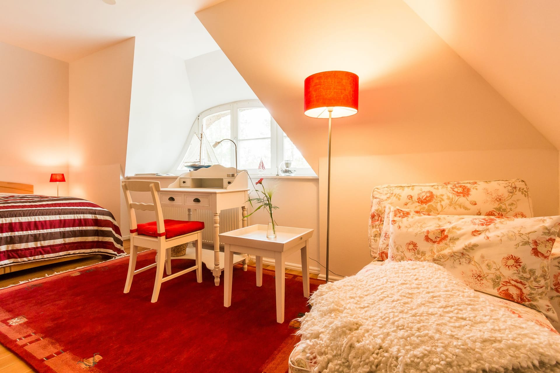 Schlafzimmer mit Doppelbett und gemütlichem Sessel