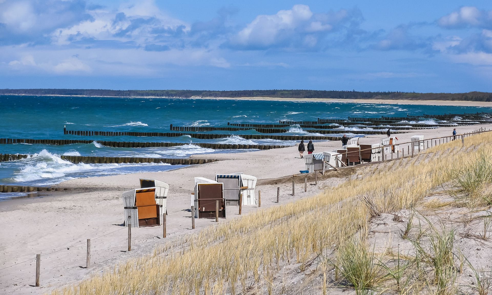 Strand mit Strandkörben und Wellen