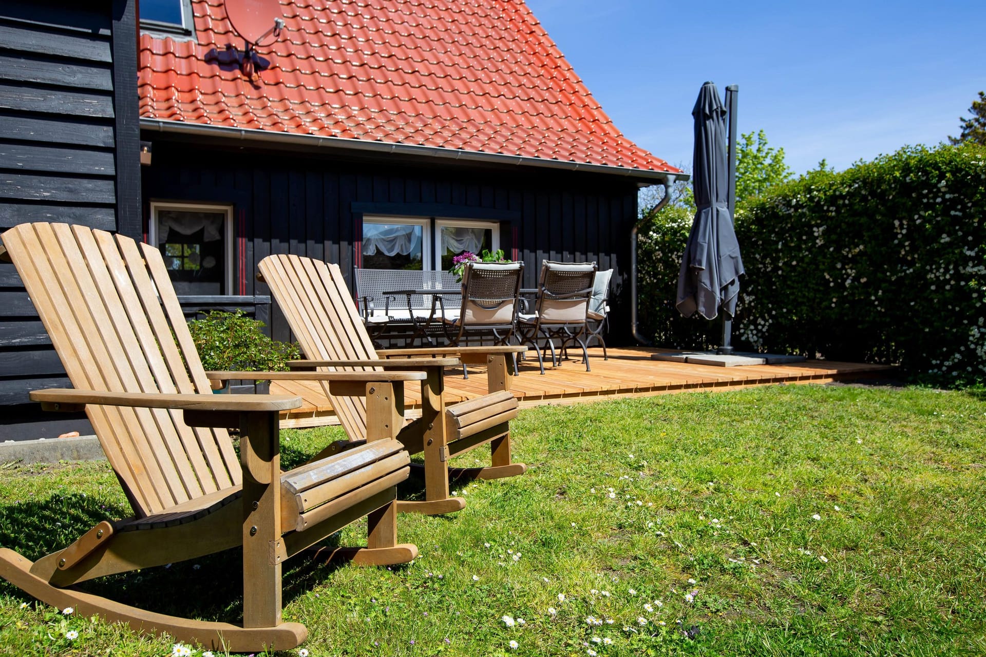 Terrasse mit Holzschaukeln und Tisch