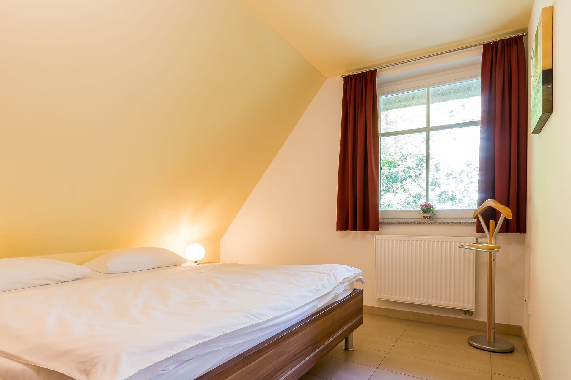 Schlafzimmer mit Doppelbett und Fenstern