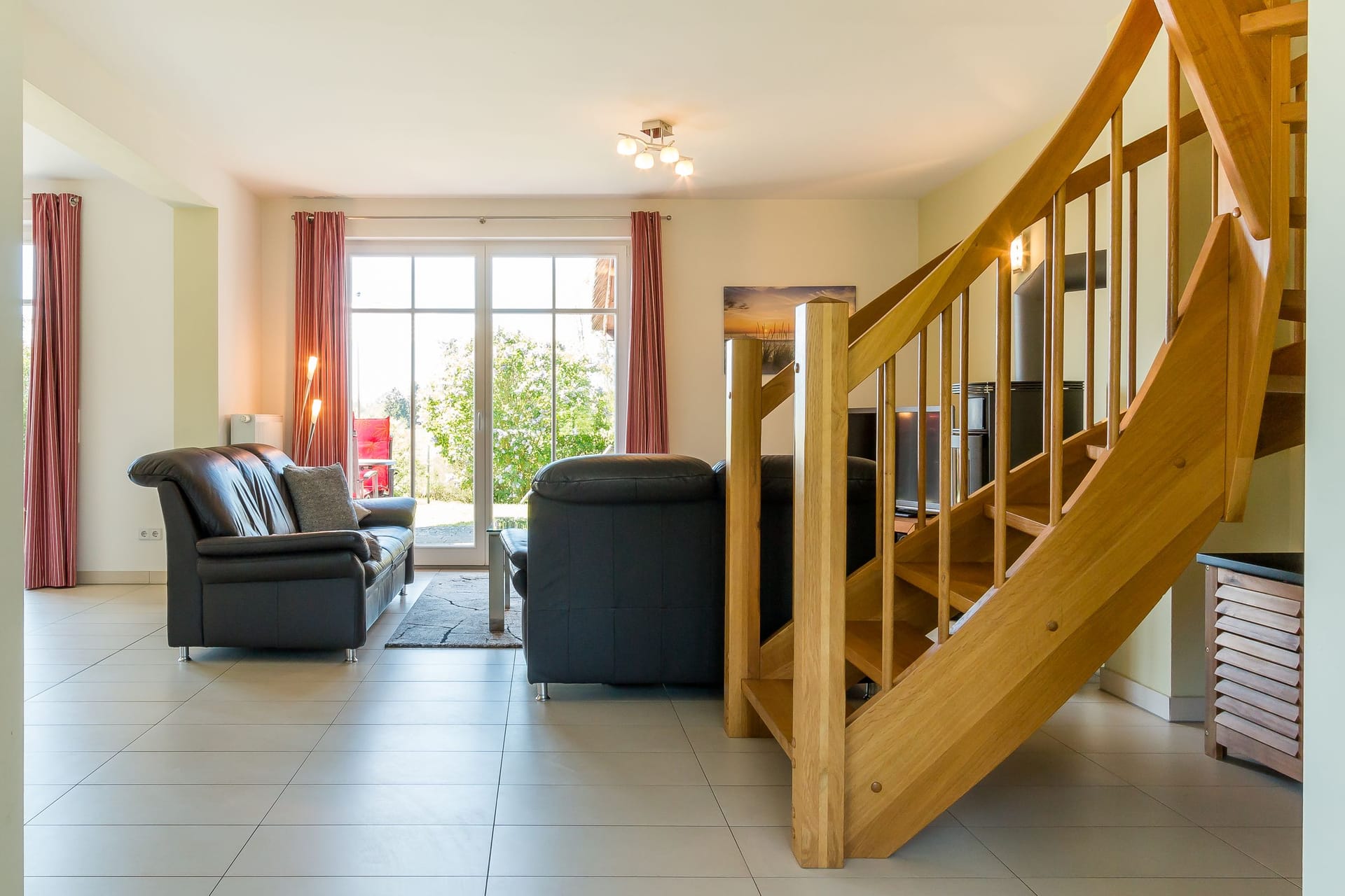 Wohnzimmer mit eleganten Sofas und Holztreppe