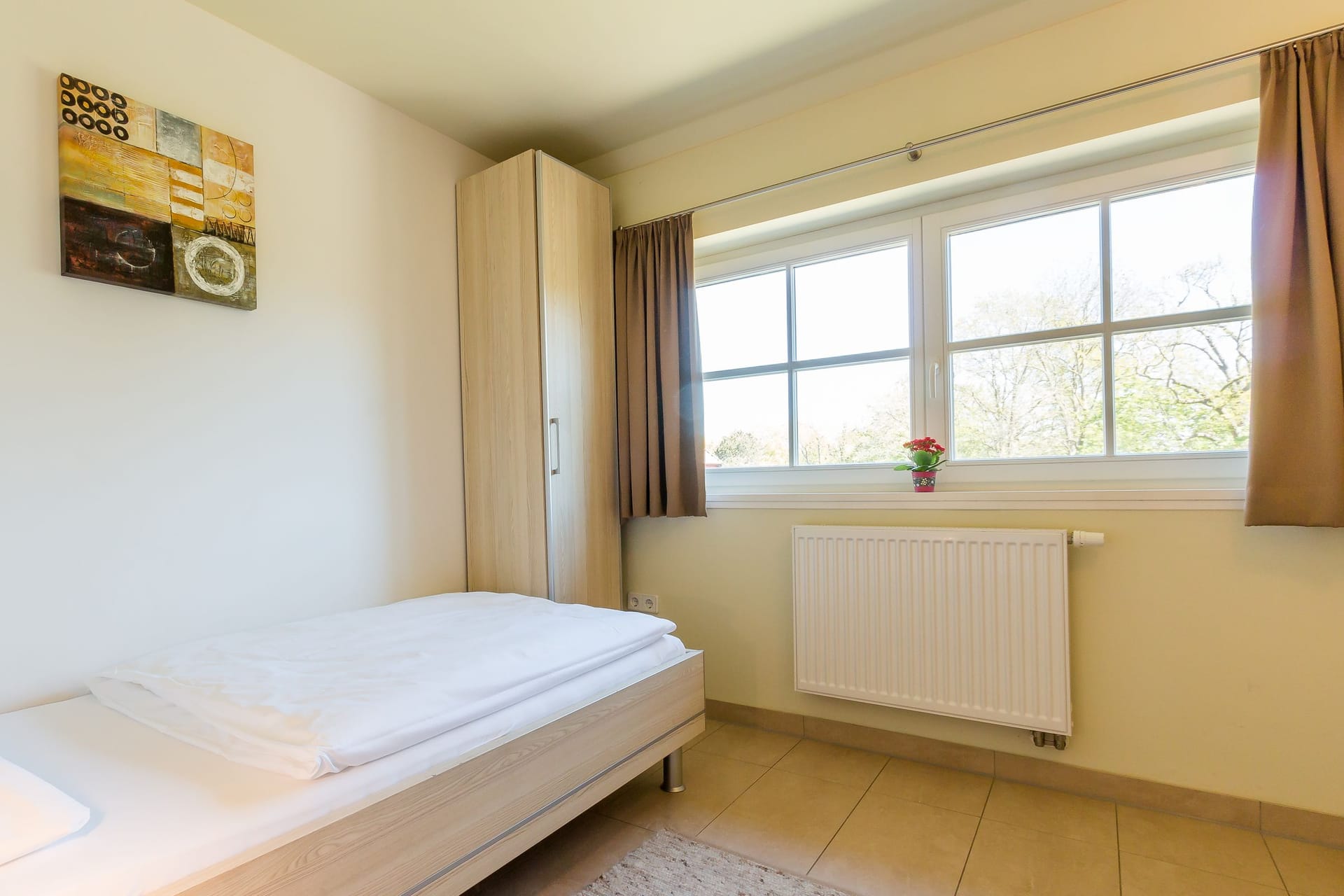Helles Schlafzimmer mit Fenster und Einzelbett