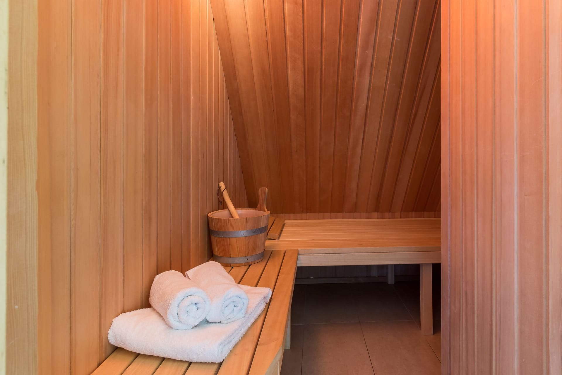 Sauna mit Holzbank und Handtüchern.