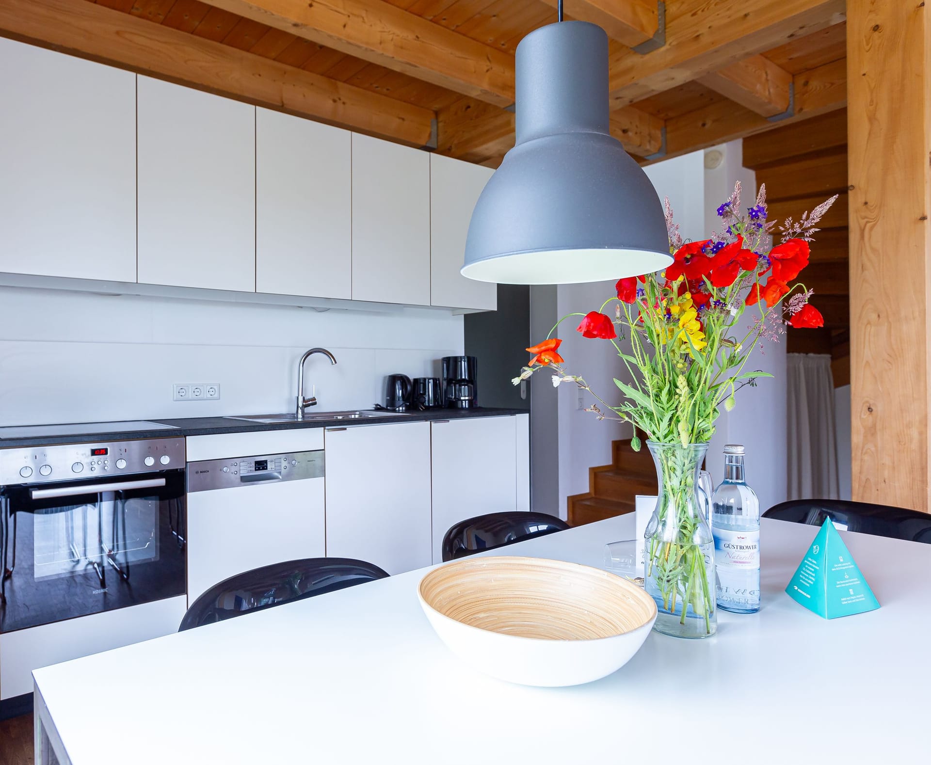 Moderne Küche mit Esstisch und frischen Blumen