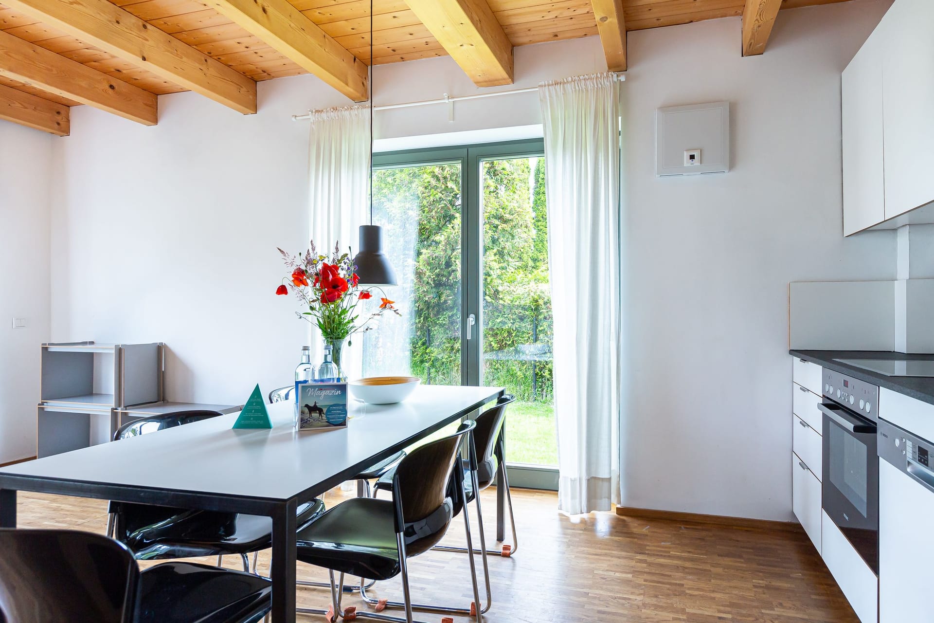 Moderne Küche mit Esstisch und Gartenausblick
