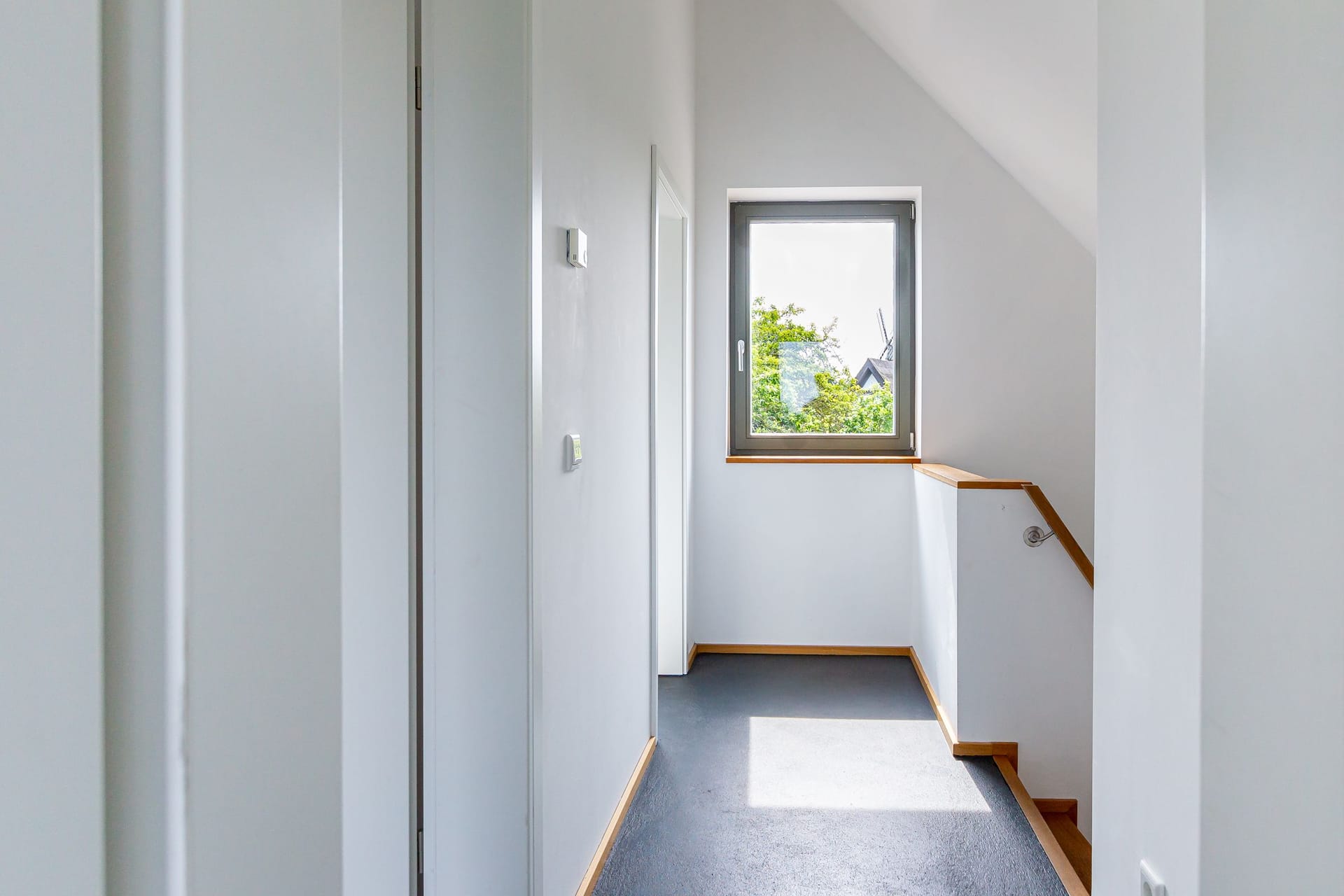 Heller Flur mit Fenster und Treppe