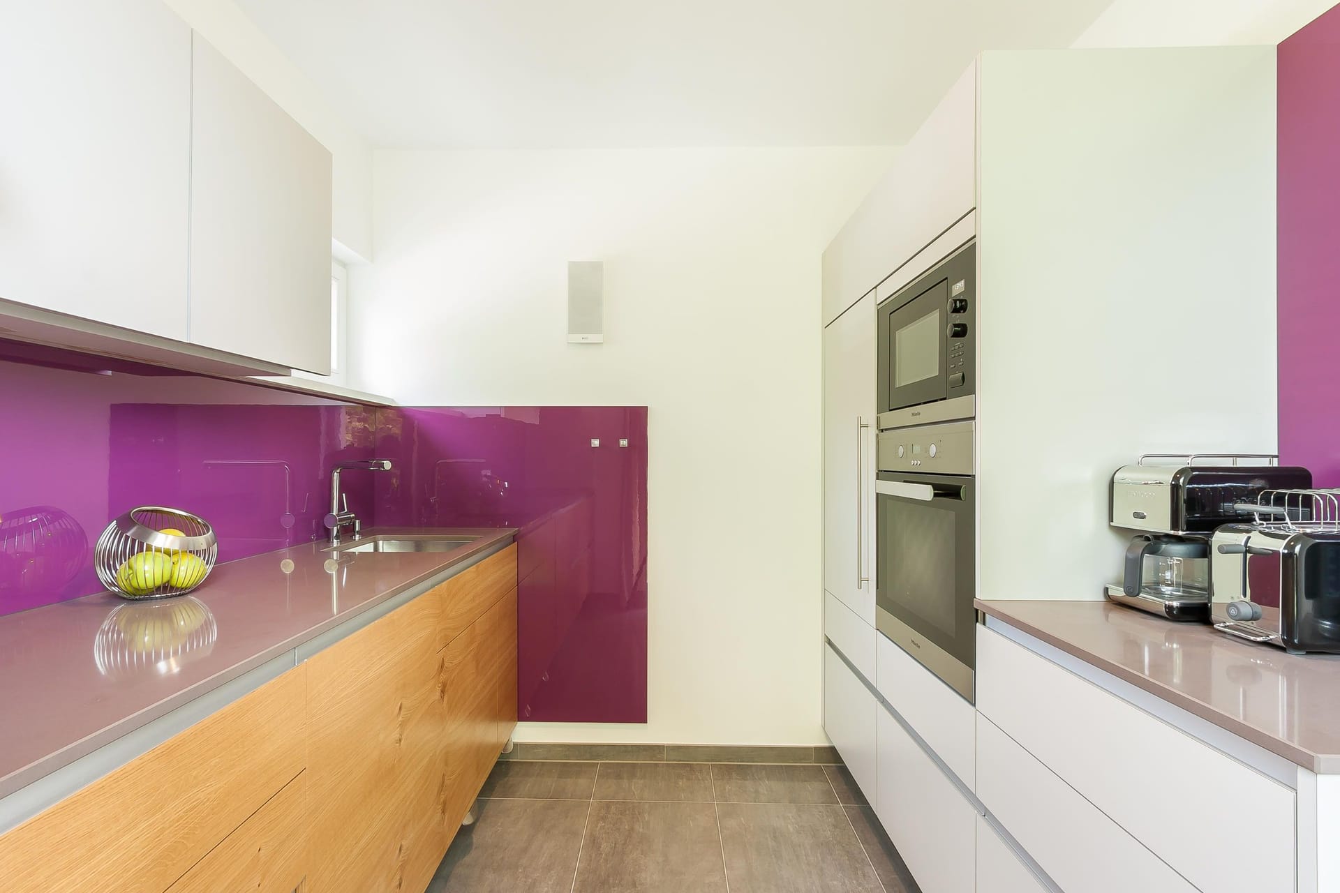 Moderne Küche mit lila Rückwand und Holzschränken