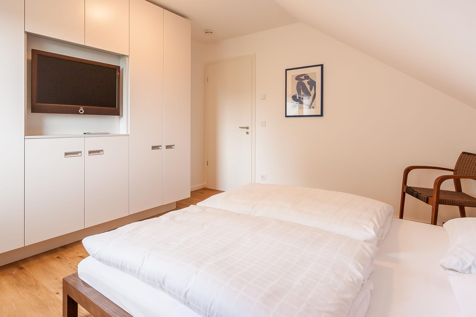 Schlafzimmer mit Doppelbett und Fernseher