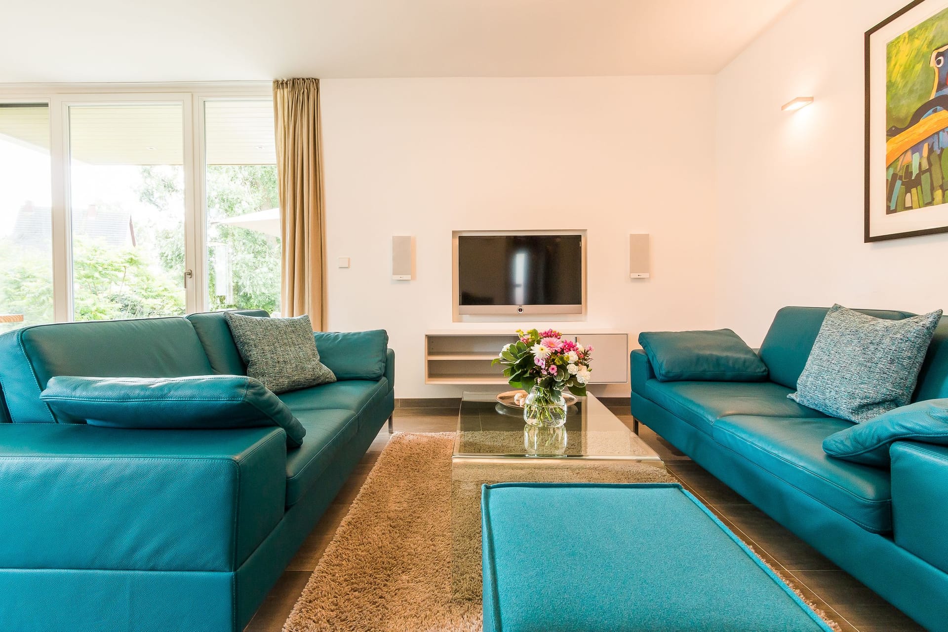 Heller Wohnraum mit blauen Sofas und Fernseher
