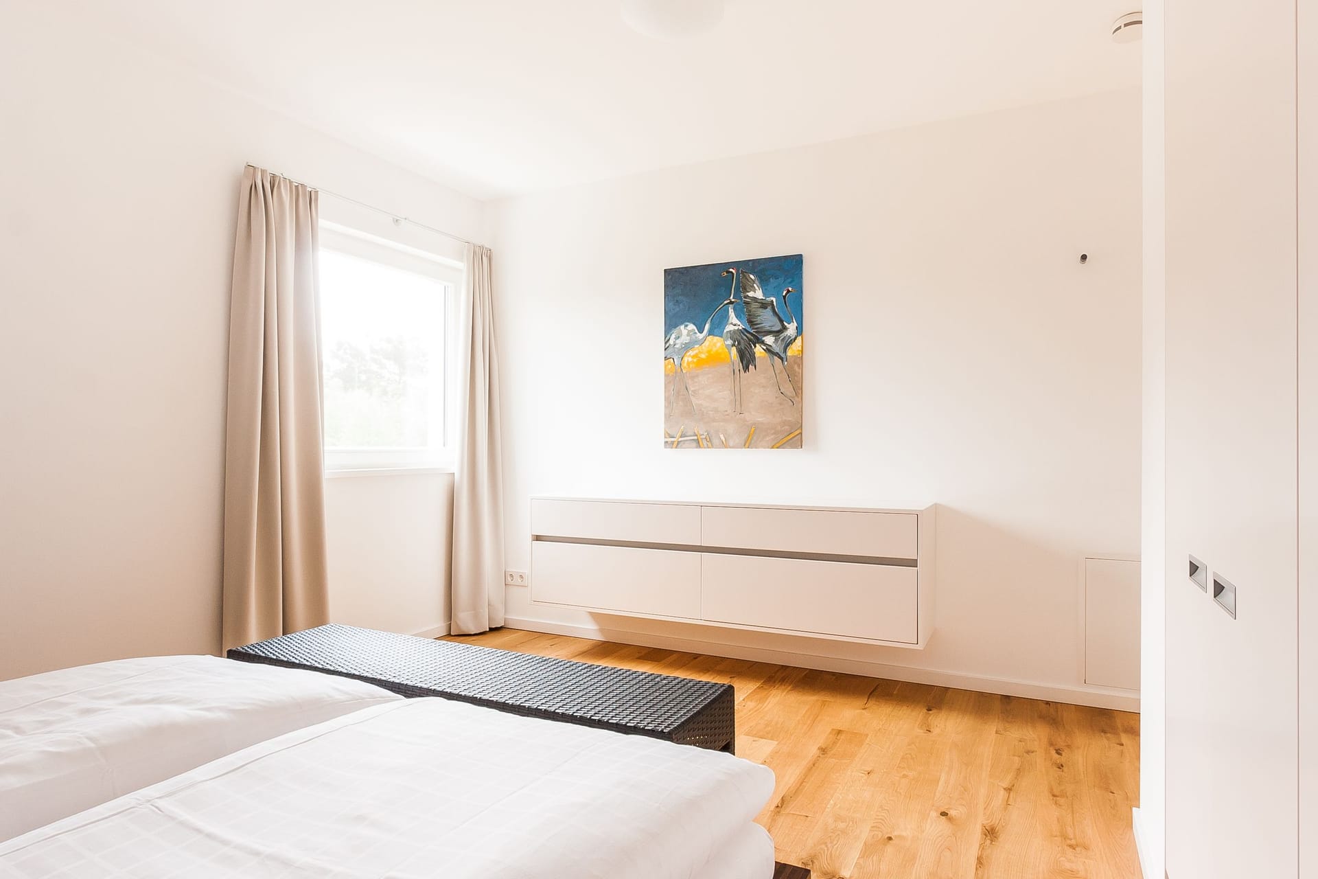 Schlafzimmer mit Doppelbett und Wandbild