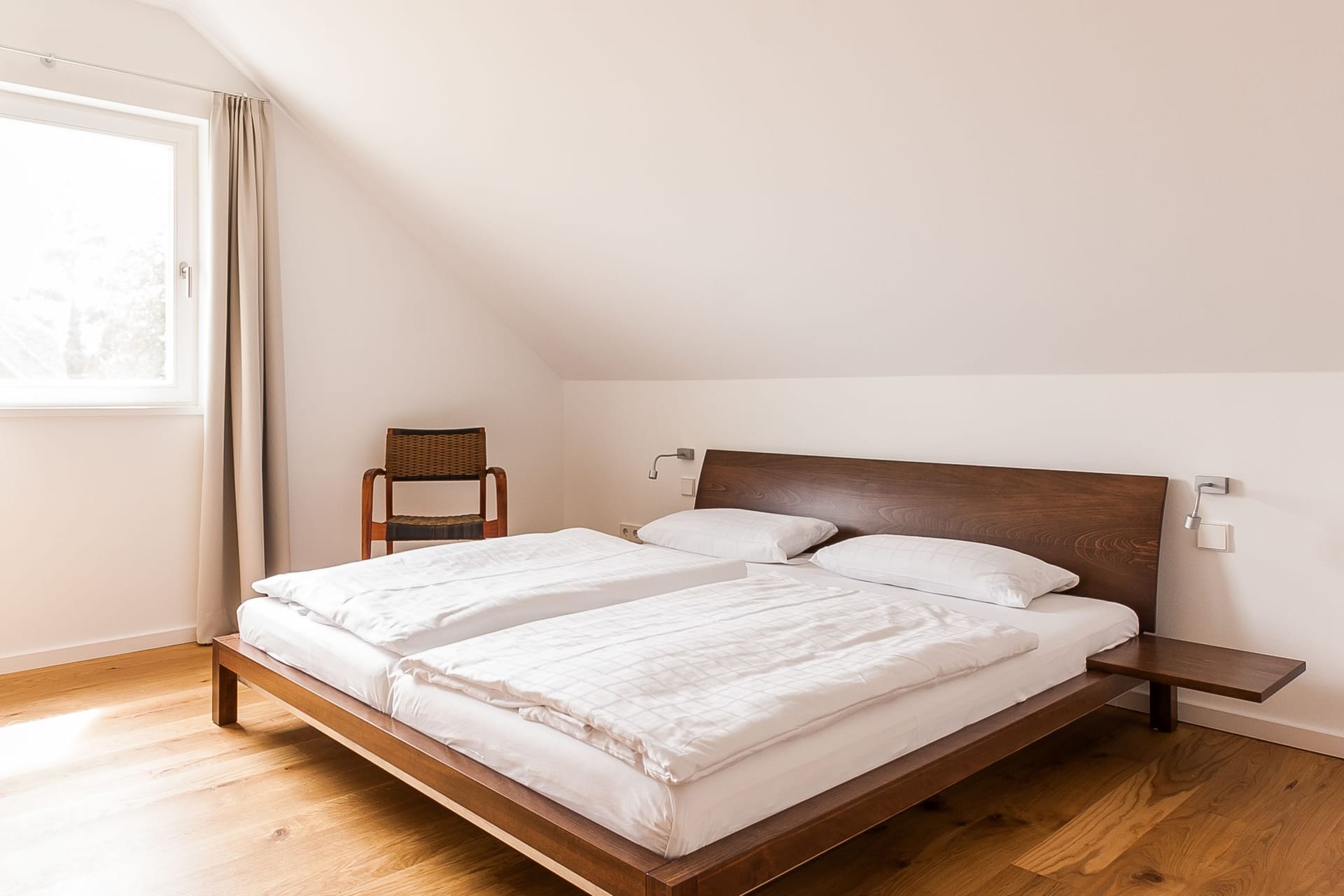 Schlafzimmer mit Doppelbett und Stuhl