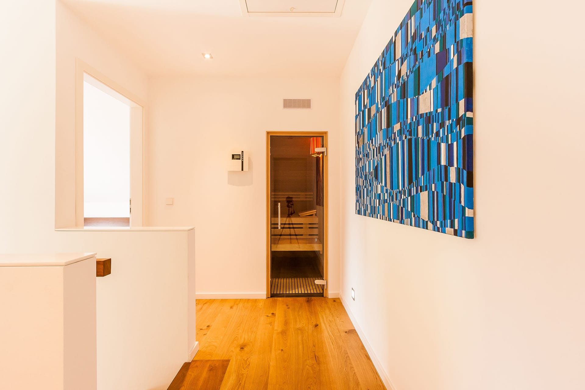 Heller Flur mit Holzfußboden und Wandkunst