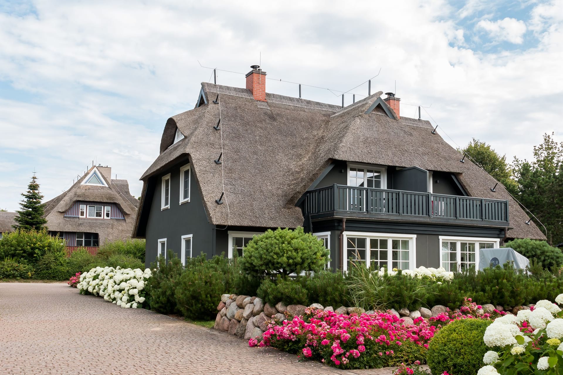 Außenansicht eines Reetdachhauses mit Balkon