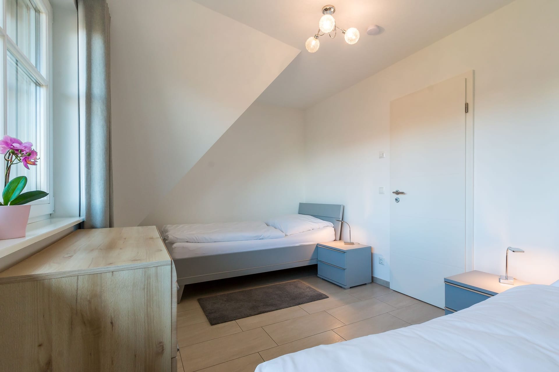Schlafzimmer mit zwei Betten und einem Fenster.