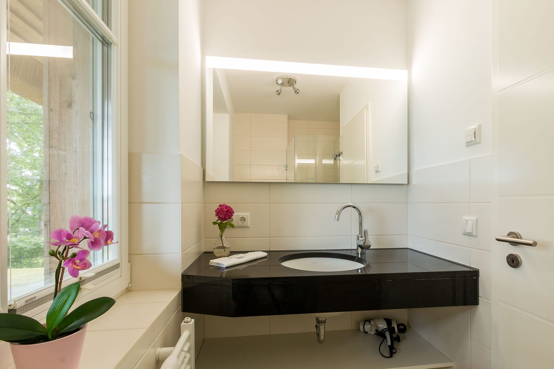 Modernes Badezimmer mit Fenster und eleganter Ausstattung
