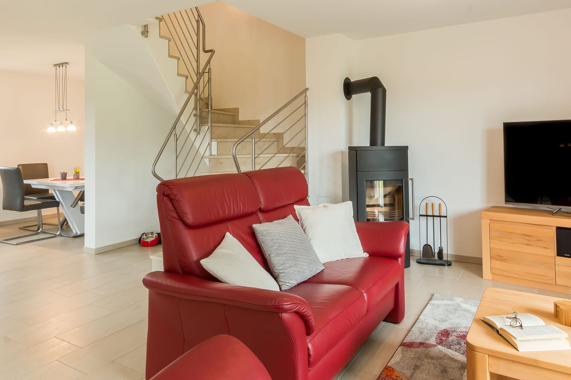 Wohnzimmer mit rotem Sofa und Kamin