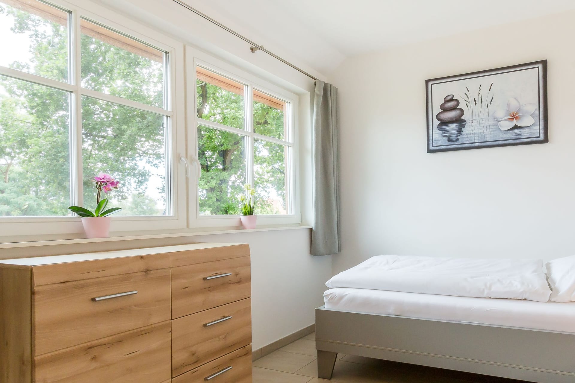 Helles Schlafzimmer mit Bett und Kommode