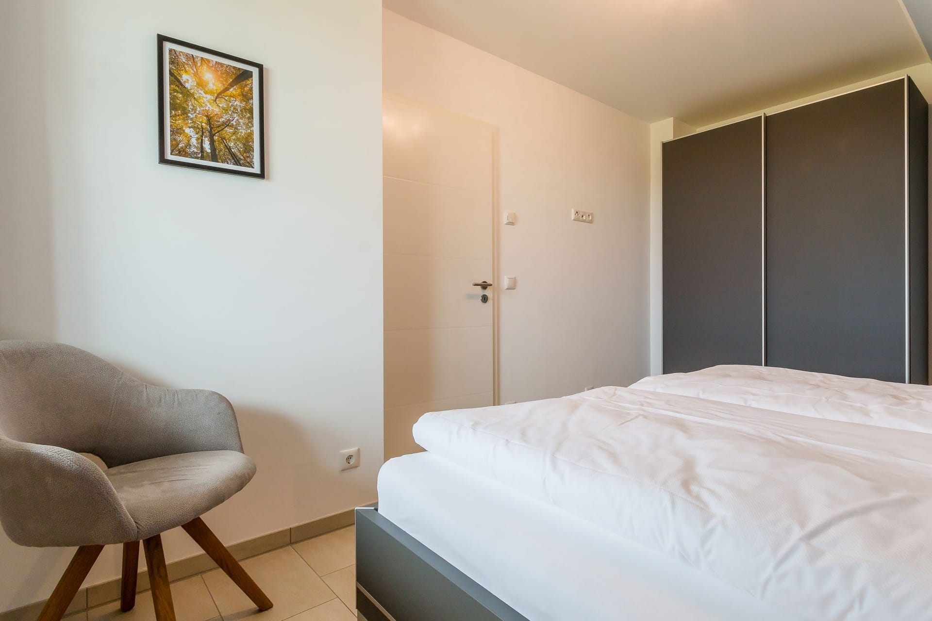 Modernes Schlafzimmer mit Doppelbett und Stuhl