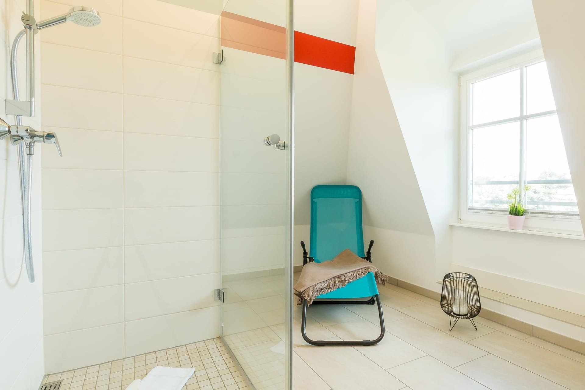 Modernes Badezimmer mit Dusche und Liegestuhl