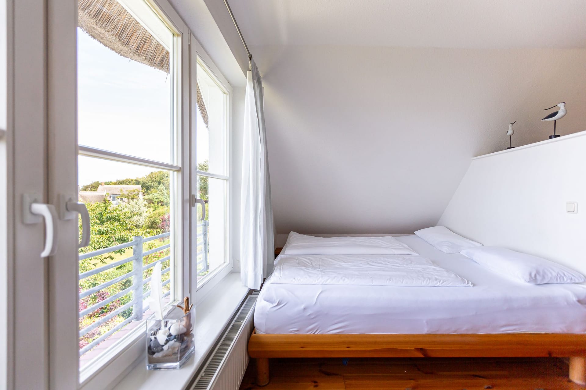 Schlafzimmer mit Doppelbett und Fensterblick